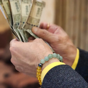 Crystal Money Magnet Bracelet worn while holding cash in hand for attracting wealth